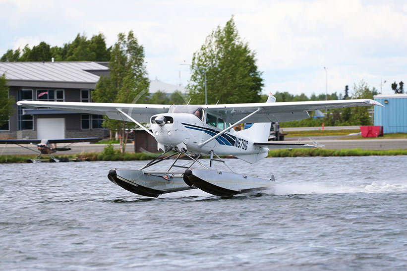 Float plane taking off from lake hood